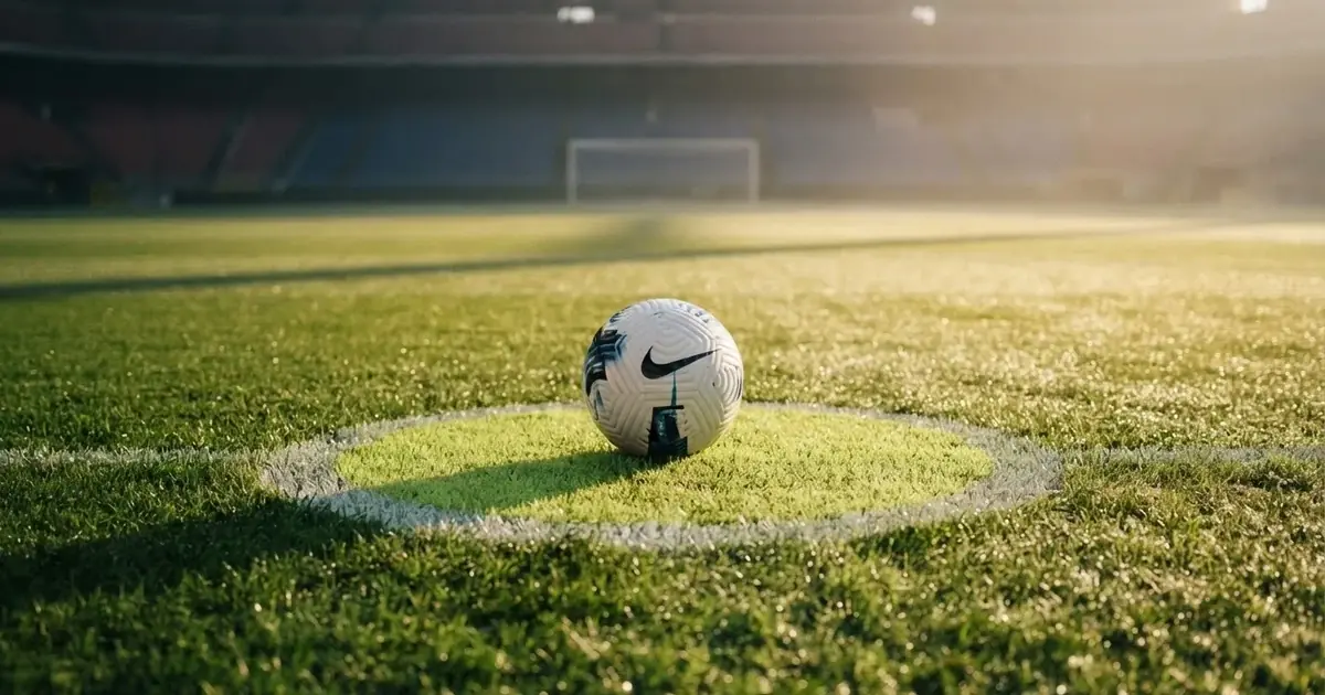A ball on the centre spot of a grass pitch in morning light